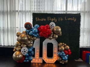 marquee numbers, balloon decor and green boxwood wall